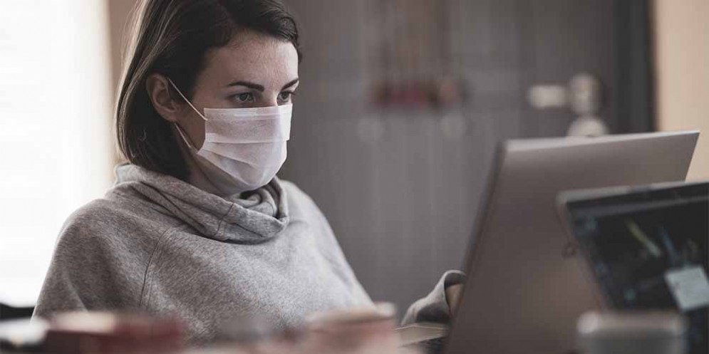 Una ragazza indossa la mascherina sul lavoro