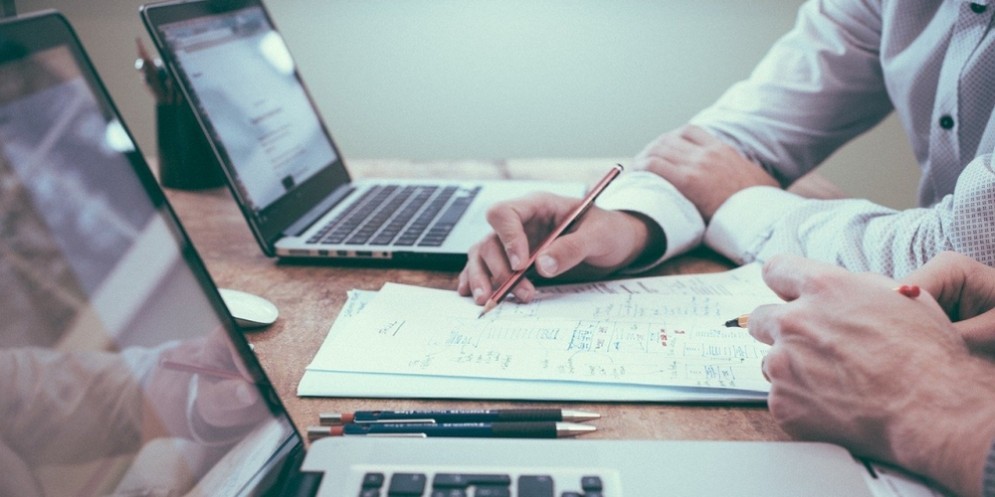 Due persone con portatili al lavoro